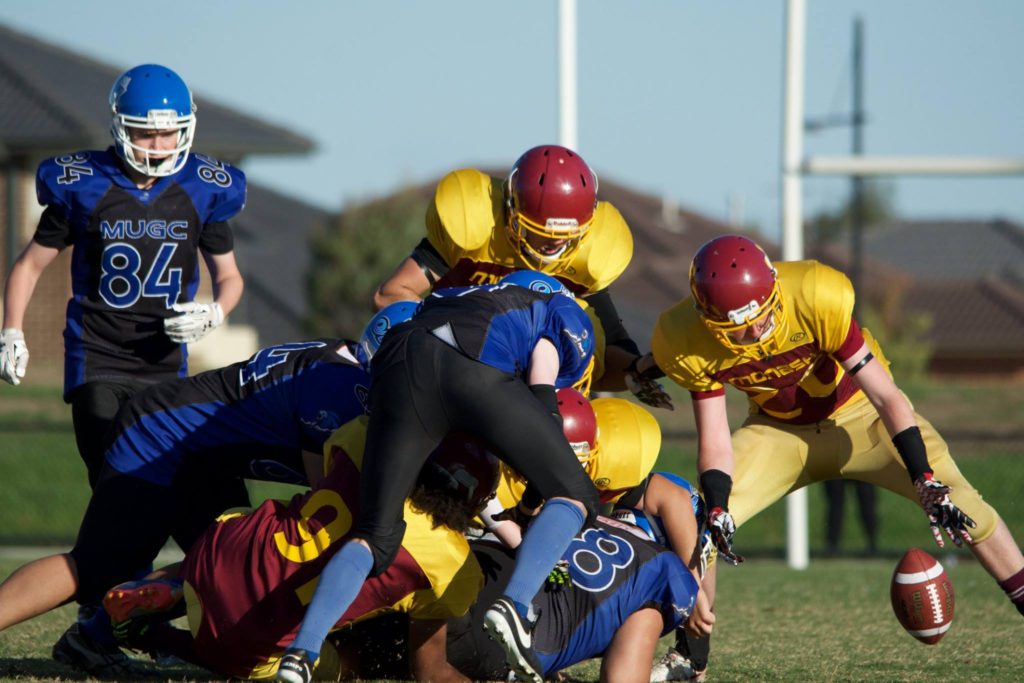 Jed Melican scoops up a fumble forced from a strip within the pile. (Photo courtesy of Bruce Rachon)